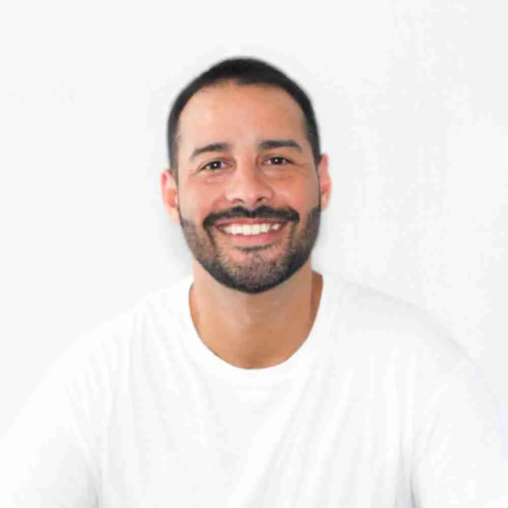 Smiling man at desk with laptop. Entrepreneur, remote worker, or digital nomad concept.